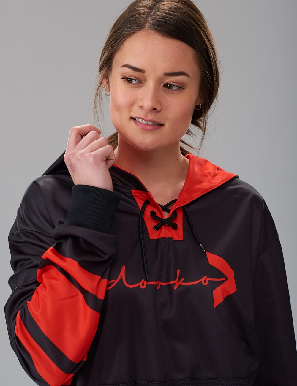 female model wearing a black lace-up hoodie with red stripes
